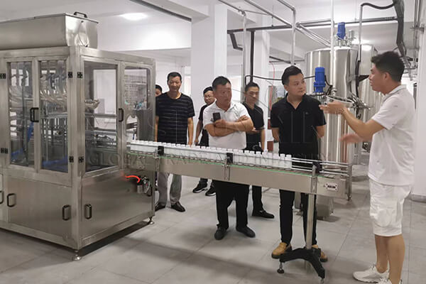 Visita de un cliente a una máquina de llenado de líquidos